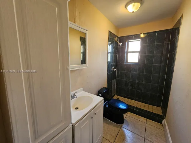 a bathroom with a shower a toilet and a sink