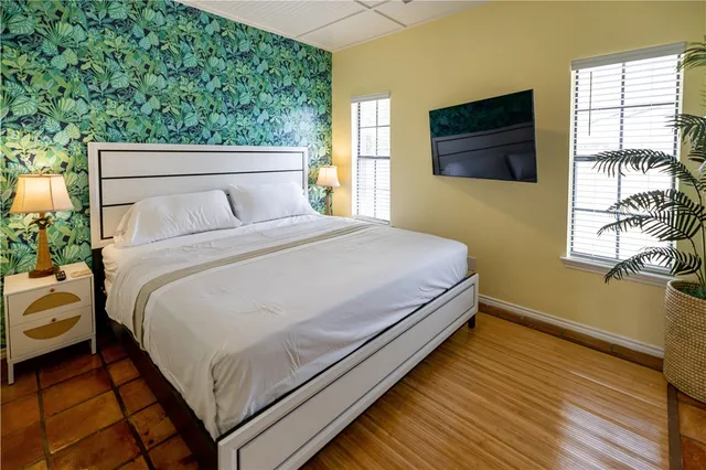 a bedroom with a bed and a flat tv screen on dresser