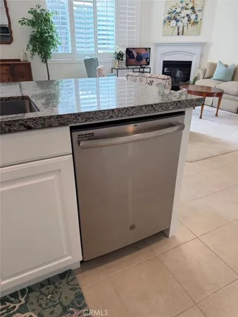 a kitchen with granite countertop a sink a stove and wooden cabinets