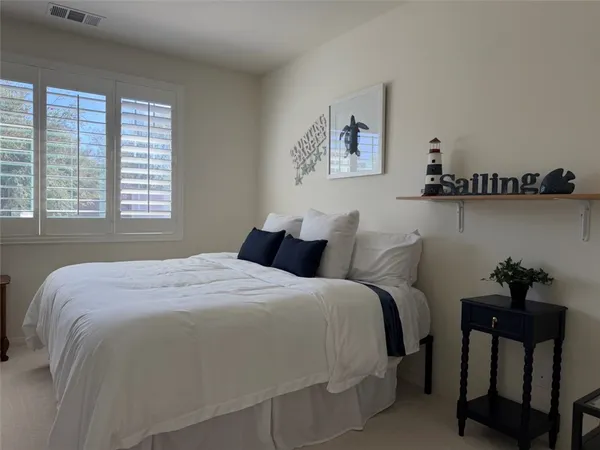 a bedroom with a bed television and window