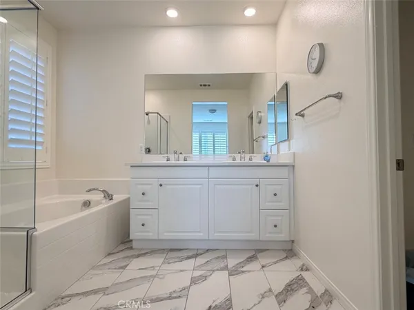 a bathroom with a bathtub sink and mirror