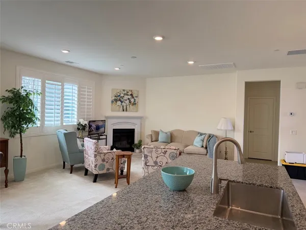 a living room with furniture a potted plant and a fireplace