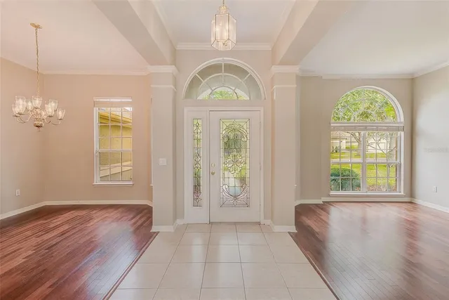 a view of an empty room with wooden floor and a bathroom