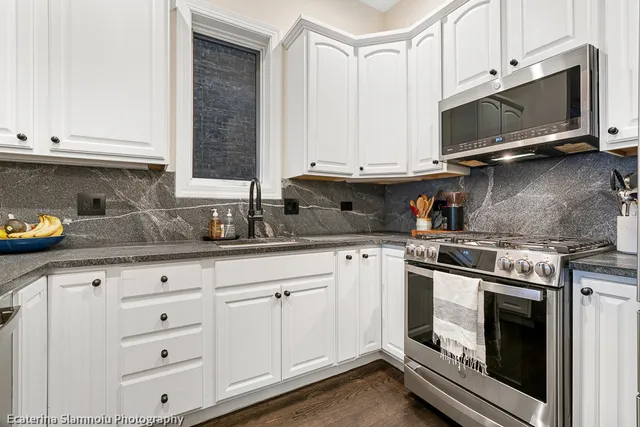 a kitchen with granite countertop white cabinets stainless steel appliances and sink