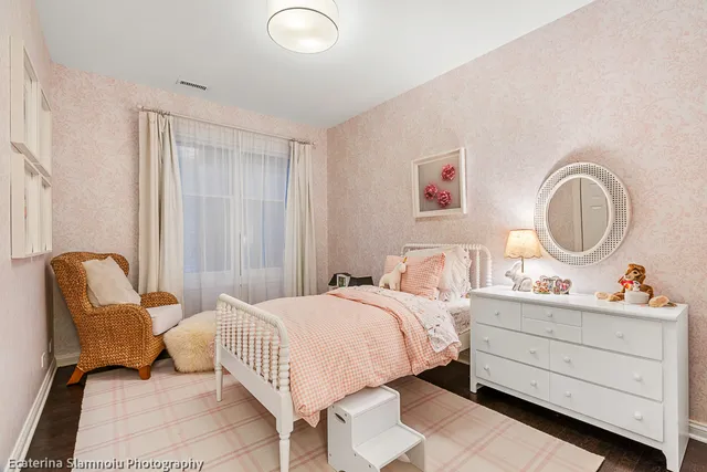 a bedroom with a bed chair and dresser