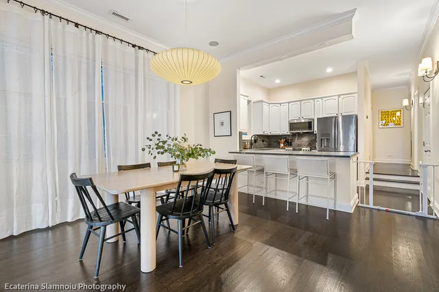 a kitchen with stainless steel appliances a table and chairs in it