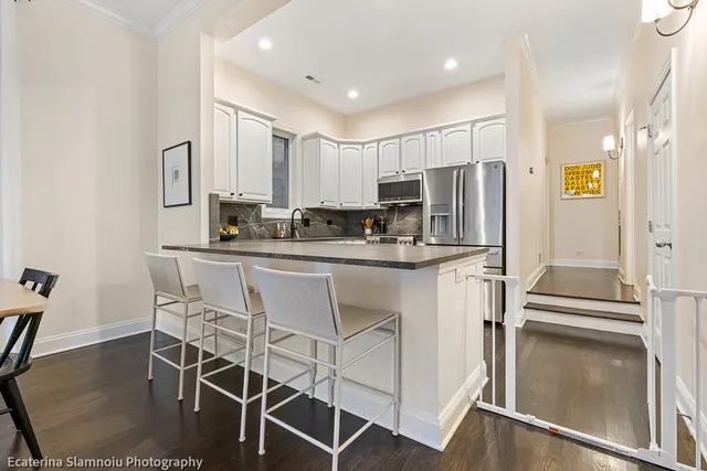 a kitchen with kitchen island white cabinets and stainless steel appliances