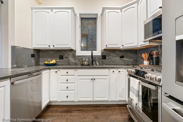a kitchen with stainless steel appliances granite countertop a stove a sink and a microwave