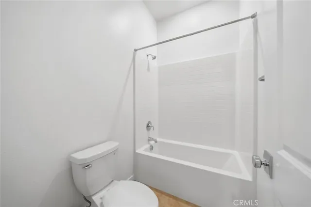 a white toilet sitting next to a bath tub