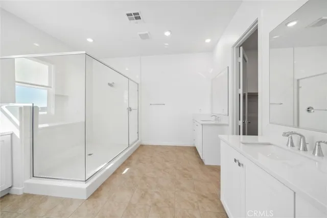 a bathroom with a double vanity sink mirror and shower