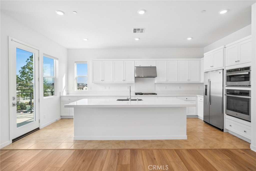 111 Baluster Irvine, CA 92618 - Photo 2 of 30 a large kitchen with stainless steel appliances a large counter top a stove and a refrigerator