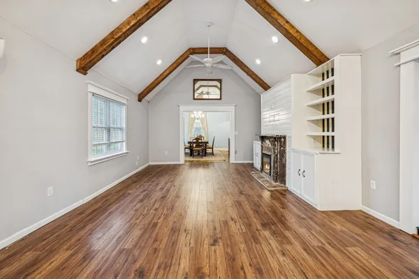a kitchen with kitchen island granite countertop a refrigerator oven a sink dishwasher and white cabinets with wooden floor