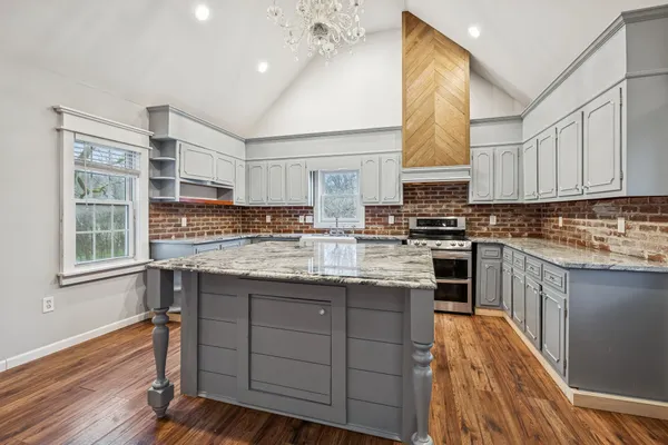 a kitchen with stainless steel appliances granite countertop a sink stove and cabinets