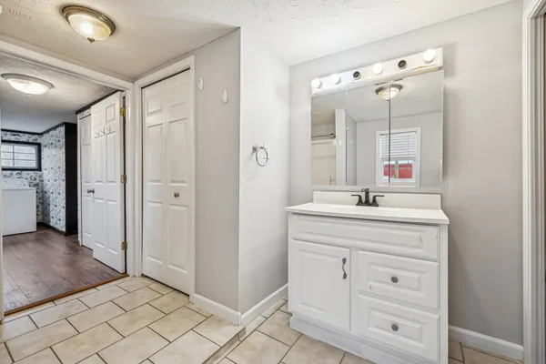 a view of an empty room with closet and a window