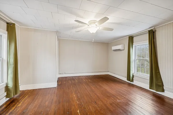 a view of a room with wooden floor and white walls