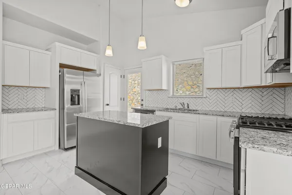 a kitchen with stainless steel appliances granite countertop a sink stove and refrigerator