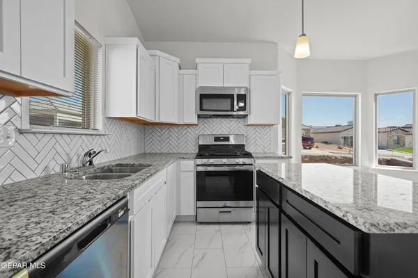 a kitchen with stainless steel appliances granite countertop a sink stove and cabinets