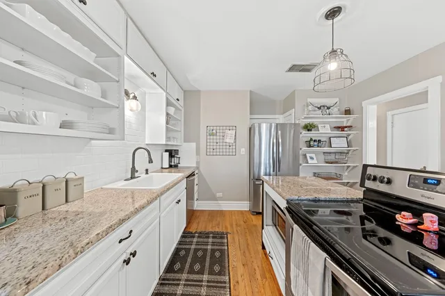 a kitchen with granite countertop a stove and a sink