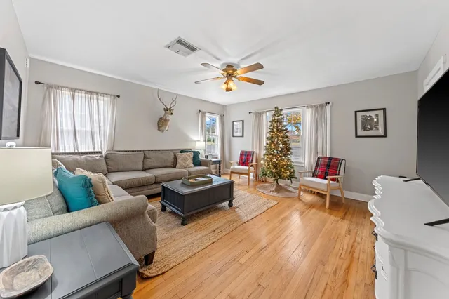 a living room with furniture and a wooden floor