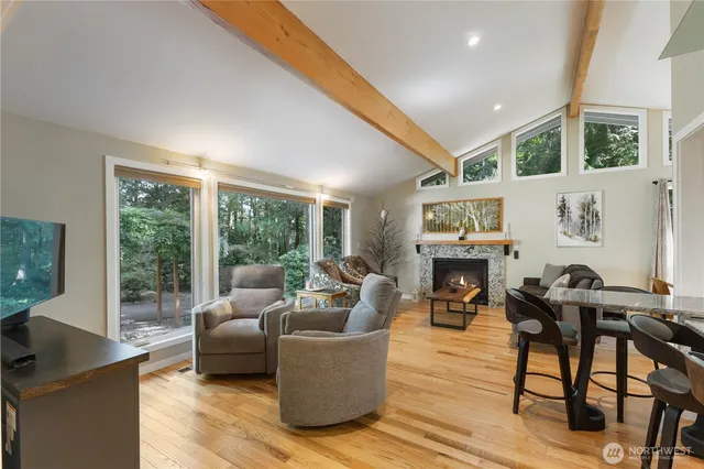 a living room with fireplace furniture and a large window