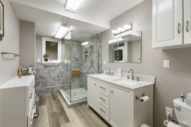 a bathroom with a sink a toilet and mirror