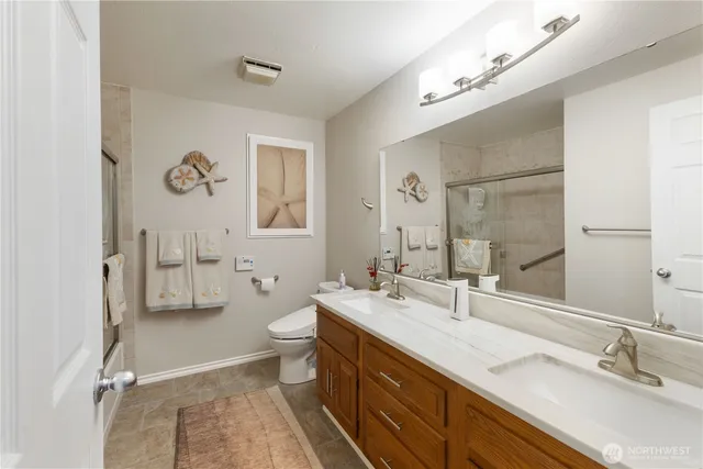 a bathroom with a double vanity sink mirror and toilet