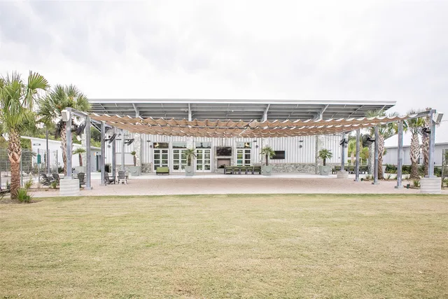 a view of a large pool with lawn chairs and large trees