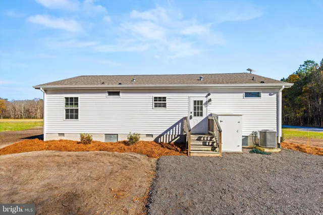 a view of a house with a yard garage and wooden fence