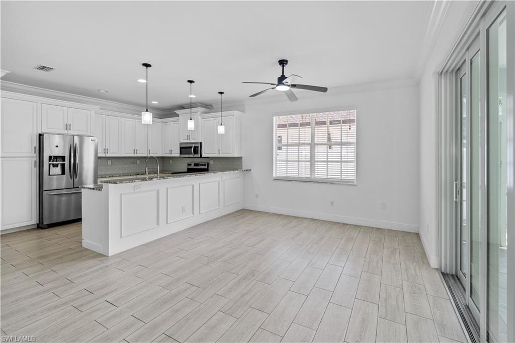183 7th Street Naples, FL 34113 - Photo 11 of 50 a large kitchen with granite countertop a white cabinets and stainless steel appliances