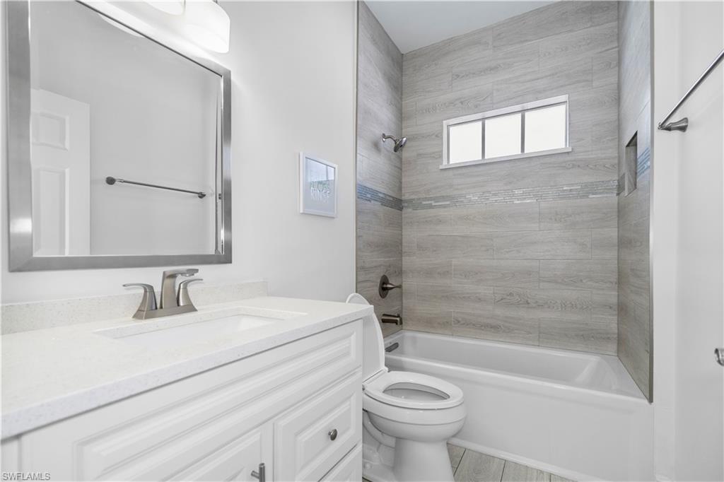 183 7th Street Naples, FL 34113 - Photo 17 of 50 a bathroom with a sink mirror toilet and bathtub