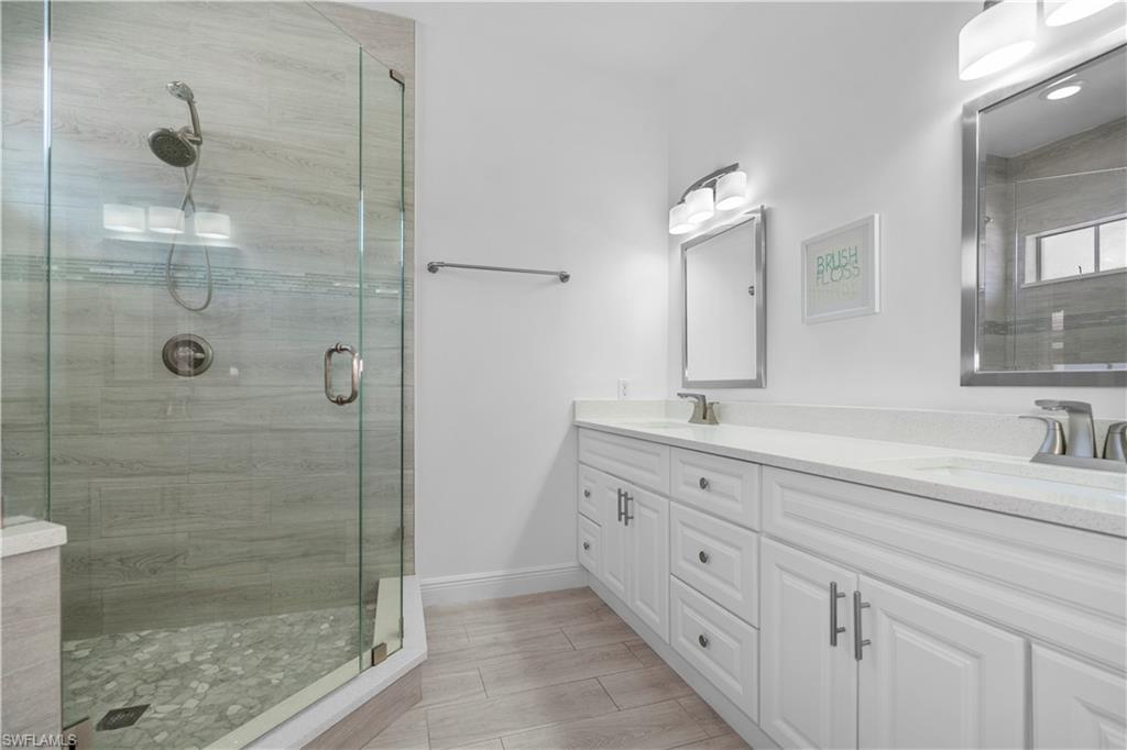 183 7th Street Naples, FL 34113 - Photo 30 of 50 a bathroom with double vanity sink and a mirror