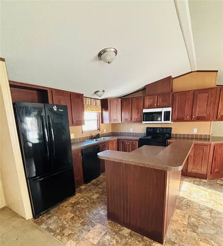 a kitchen with stainless steel appliances granite countertop a refrigerator stove and sink