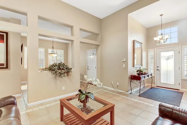 a living room with furniture and a dining table next to a window