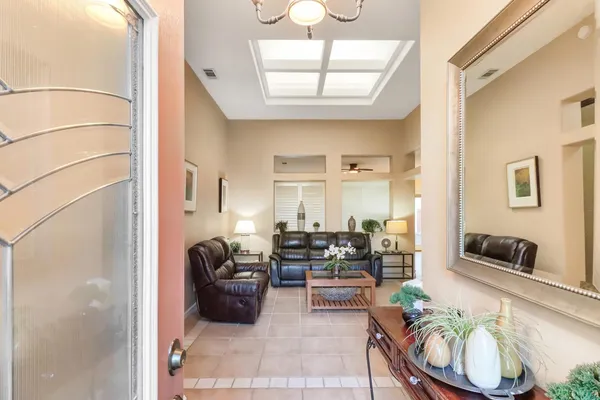 a hallway with a flower pot and a chandelier