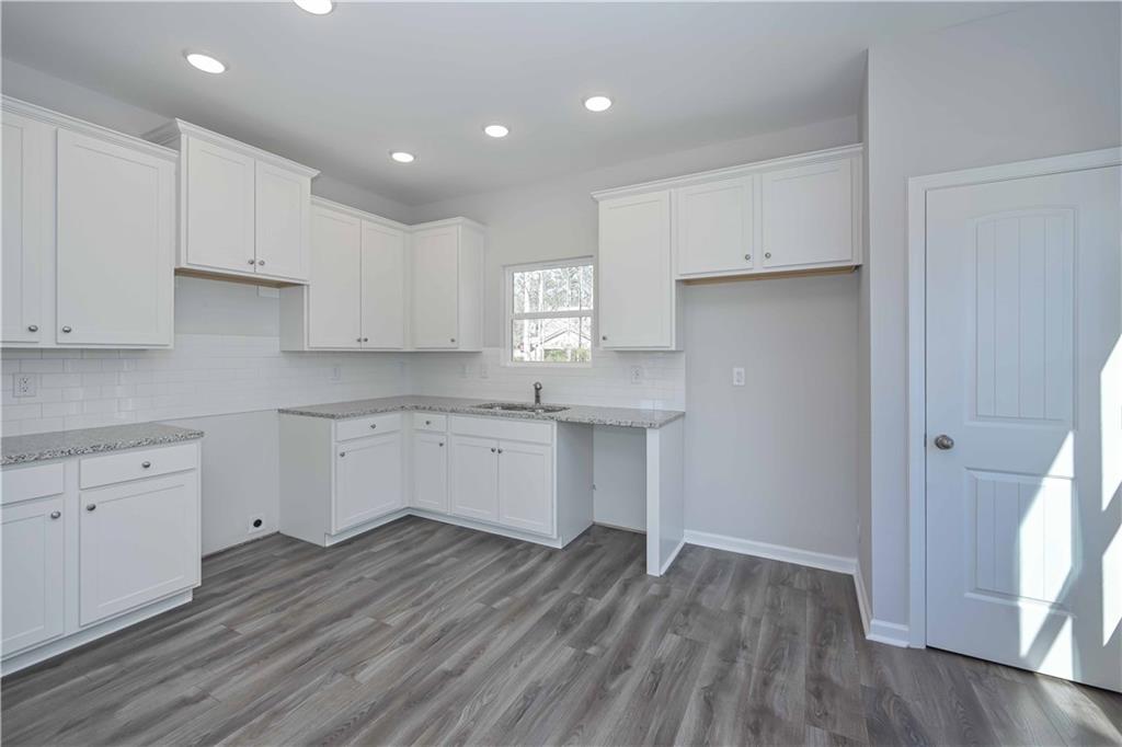 506 Charleston Place Villa Rica, GA 30180 - Photo 12 of 25 a kitchen with cabinets wooden floor and a window