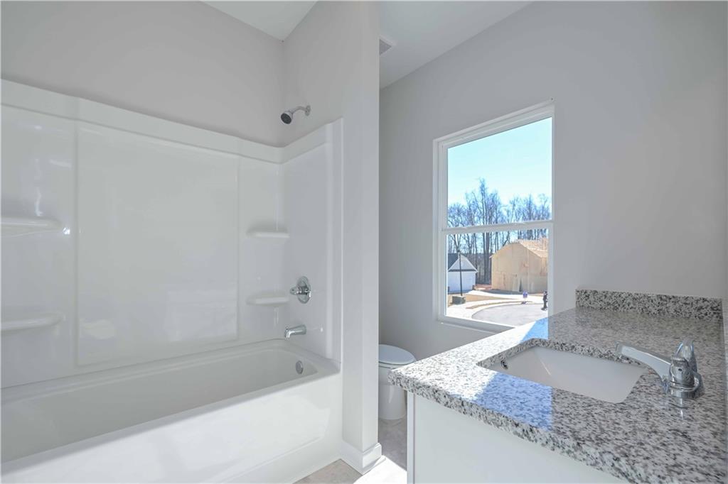 506 Charleston Place Villa Rica, GA 30180 - Photo 20 of 25 a bath room with a granite countertop sink and a mirror