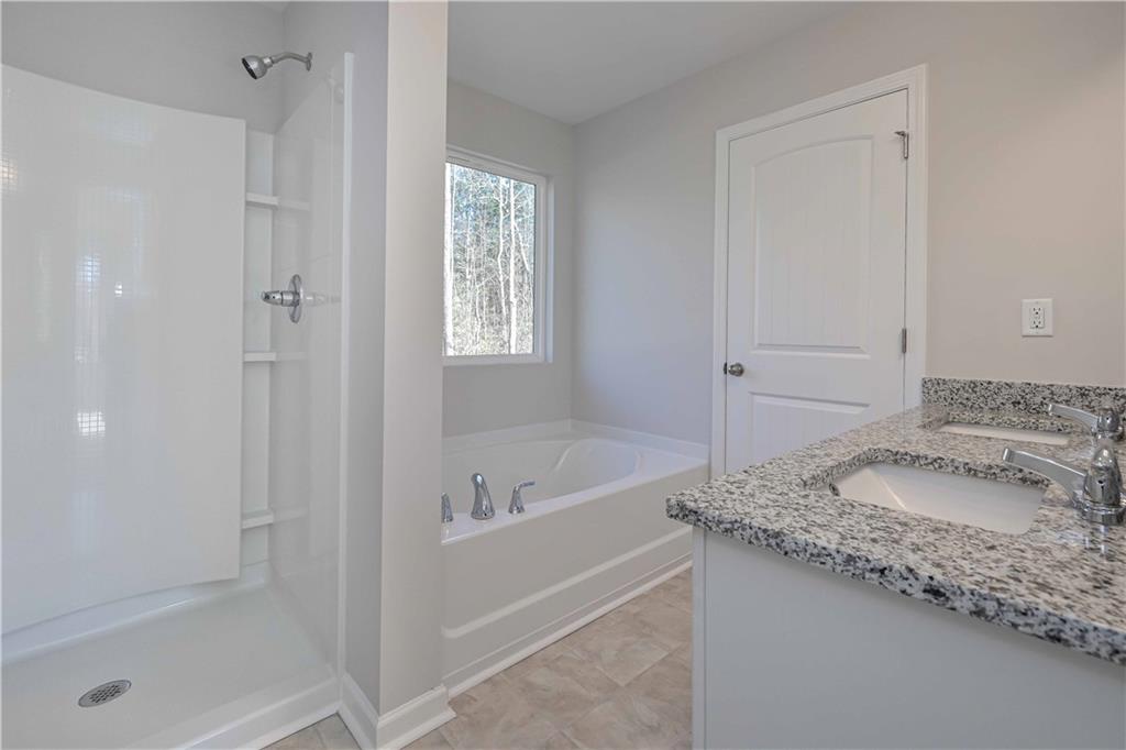 506 Charleston Place Villa Rica, GA 30180 - Photo 24 of 25 a bathroom with a granite countertop sink and shower