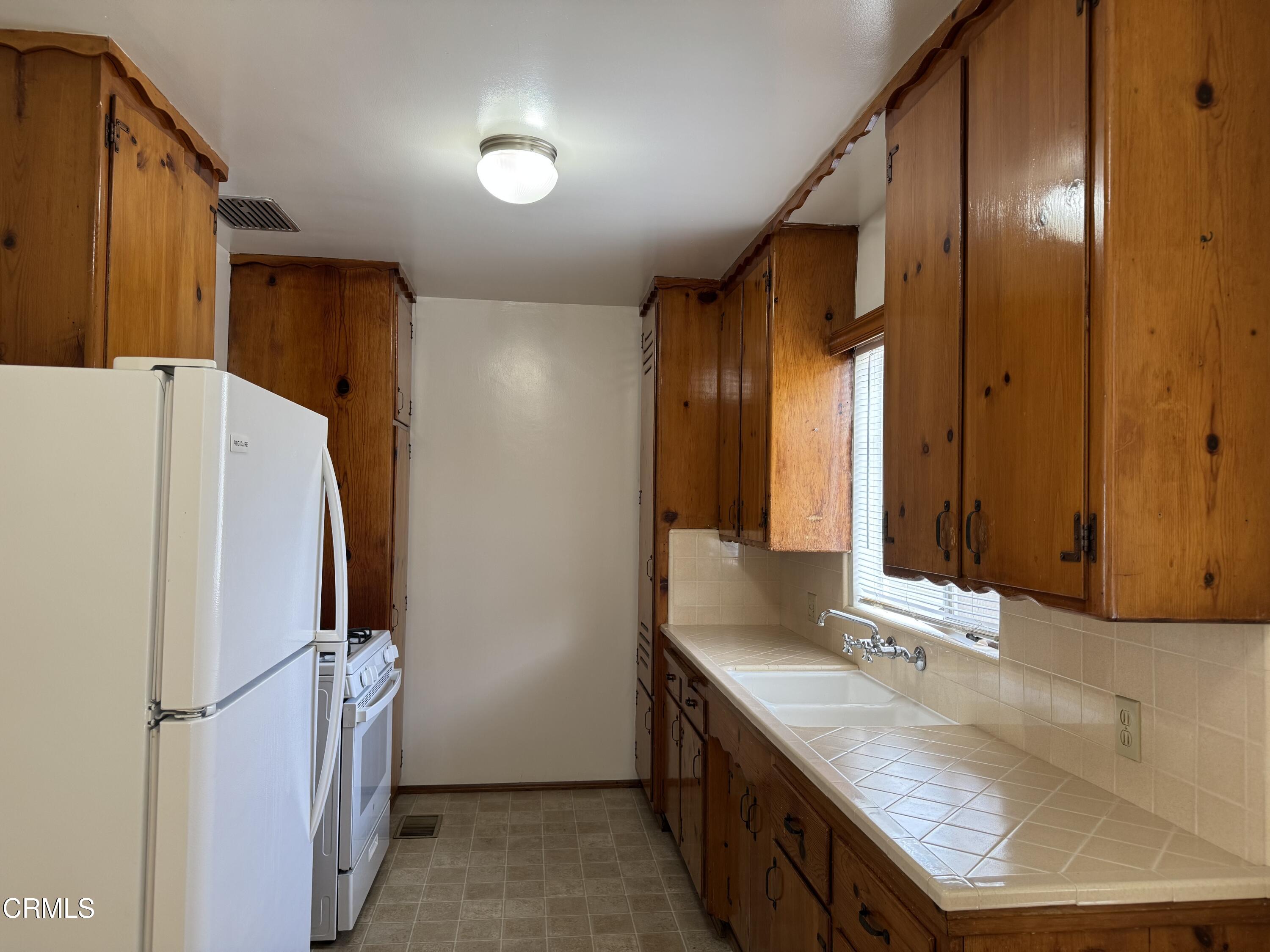 516 Linwood Avenue, Unit A Monrovia, CA 91016 - Photo 3 of 12 a bathroom with a granite countertop sink and a mirror
