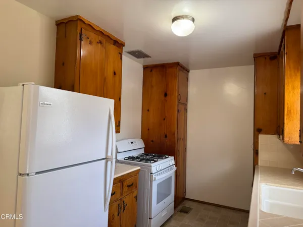 a white refrigerator freezer and a stove sitting inside of a kitchen