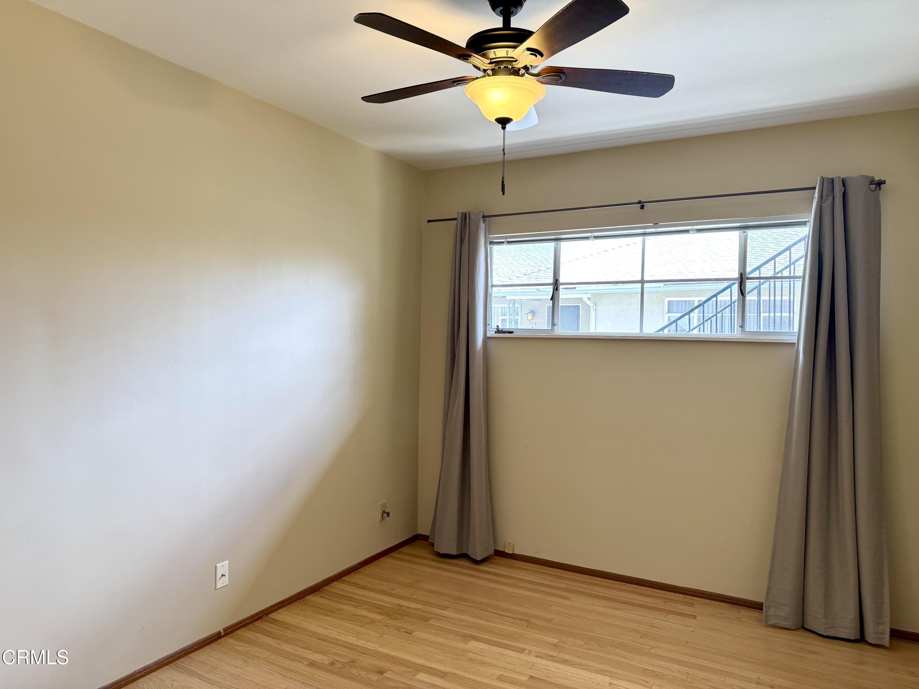 516 Linwood Avenue, Unit A Monrovia, CA 91016 - Photo 9 of 12 an empty room with wooden floor fan and windows