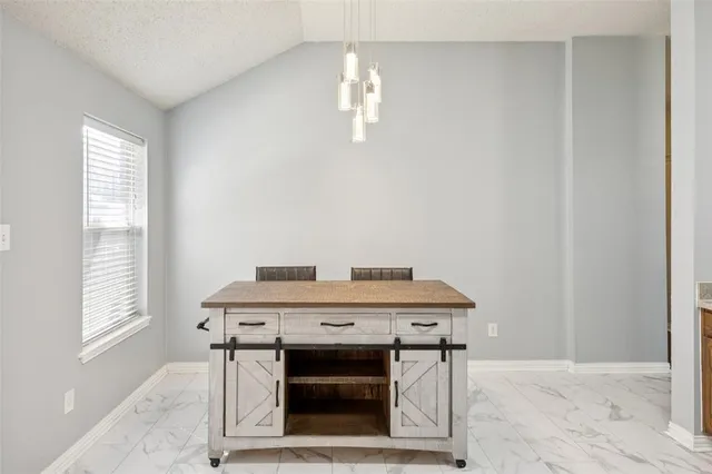 a view of a dining room with a table and chairs