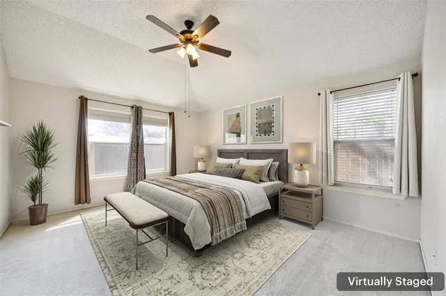 a bedroom with a large bed and a chandelier fan