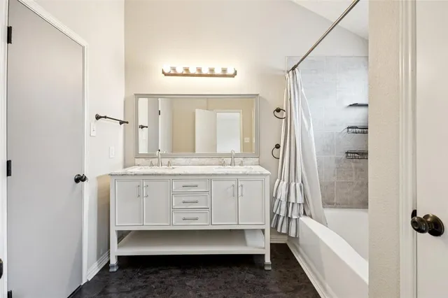 a bathroom with a tub a sink and a mirror