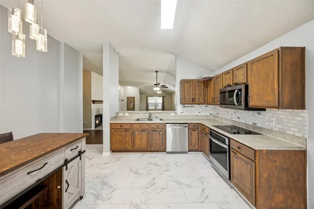 a large kitchen with stainless steel appliances granite countertop a stove refrigerator sink and dishwasher