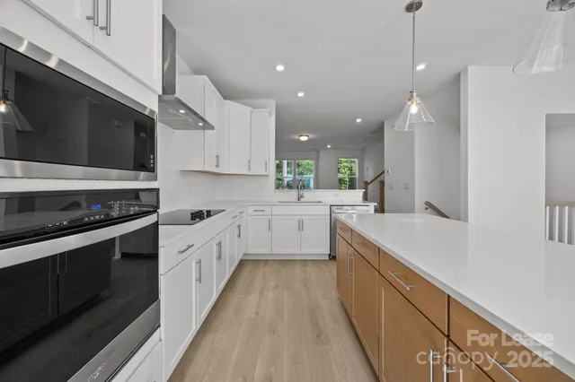 a large kitchen with stainless steel appliances kitchen island granite countertop a stove a sink and a microwave