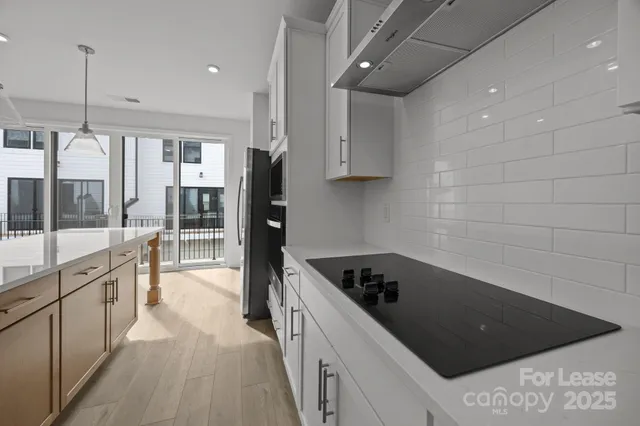 a kitchen with stainless steel appliances kitchen island granite countertop a stove a sink and a refrigerator