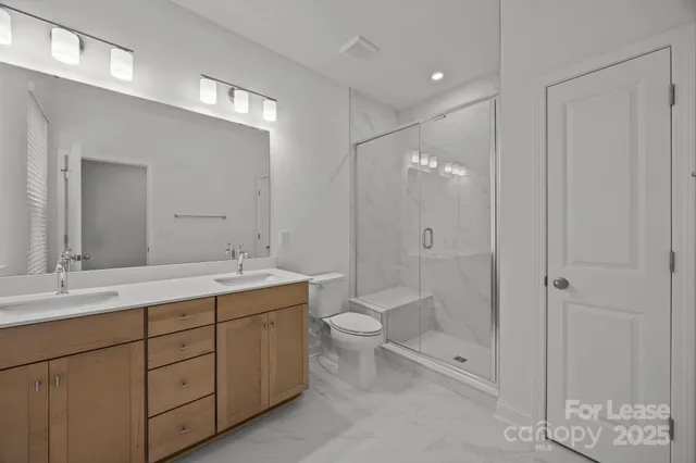 a bathroom with a double vanity sink toilet and shower