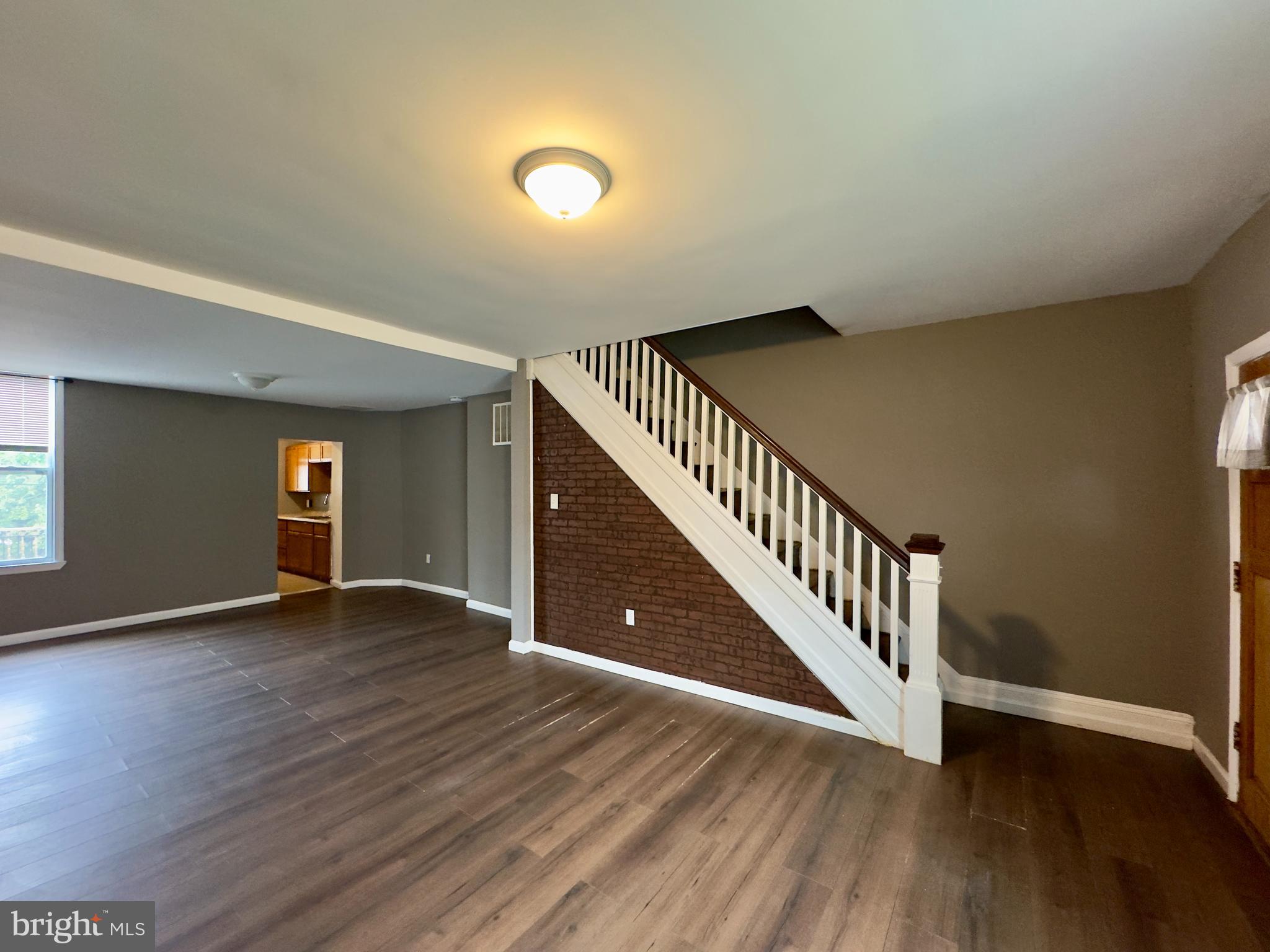 1931 Griffis Avenue Baltimore, MD 21230 - Photo 2 of 17 a view of an empty room with wooden floor and stairs