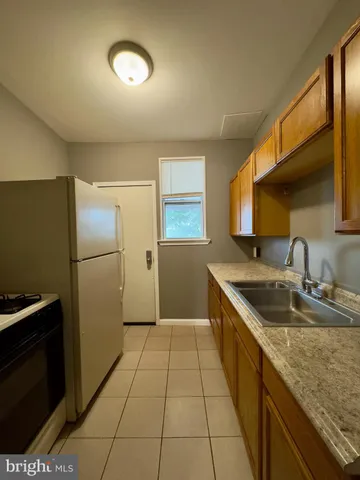 a kitchen with granite countertop a sink stove and refrigerator