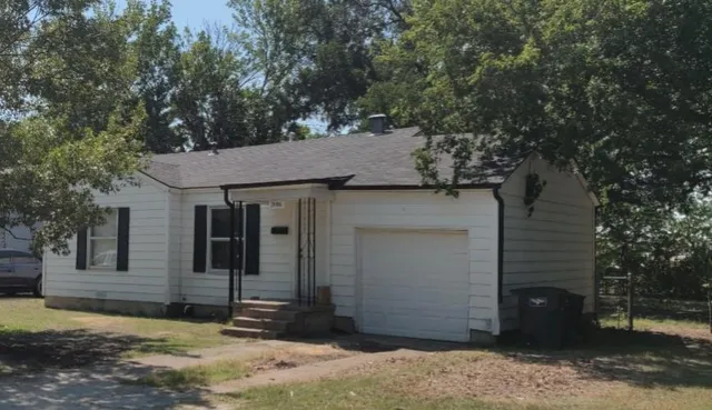 a view of a small house with large tree